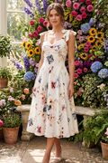 Woman in a floral dress standing in front of a colorful flower display