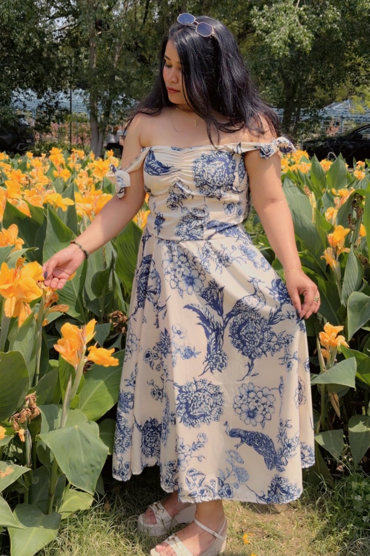 Woman in a floral dress standing among yellow flowers