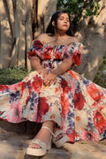 Woman in a floral dress sitting under a tree